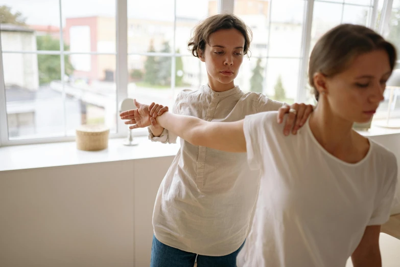 a couple of women standing next to each other, a picture, by Adam Marczyński, trending on pexels, renaissance, acupuncture treatment, arms stretched out, tied - up shirt, from the elbow