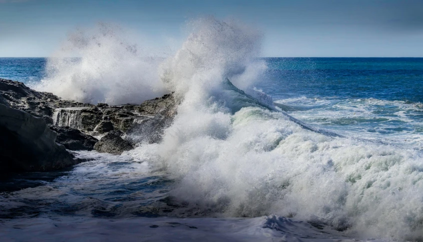 a person on a surfboard riding a wave in the ocean, pexels contest winner, photorealism, waves crashing at rocks, thunderous, sea foam, overblown