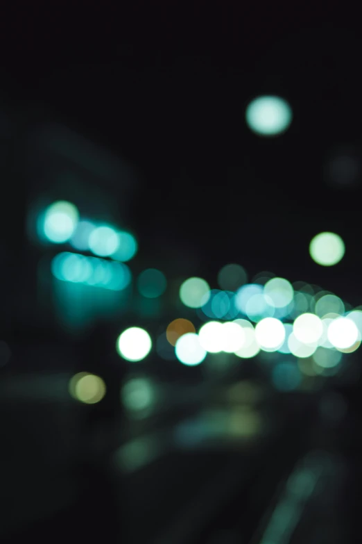 a blurry photo of a city street at night, inspired by Elsa Bleda, unsplash, happening, blue - green tones, bokeh. i, bokeh”