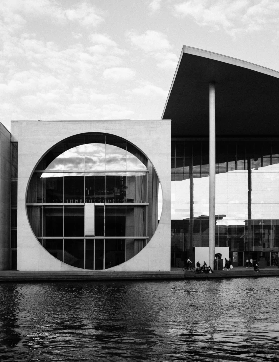 a black and white photo of a building, inspired by David Chipperfield, pexels contest winner, huge black circle, german chancellor, at the waterside, framing