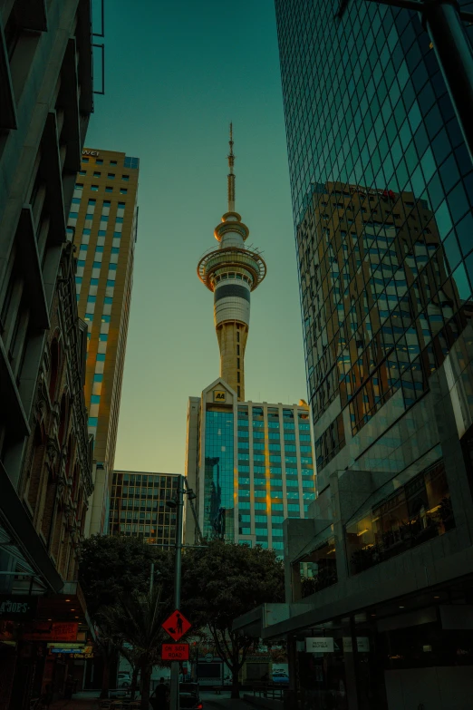 a tall tower towering over a city street, by Matt Stewart, unsplash contest winner, hurufiyya, maori, golden towers, vivid), central hub