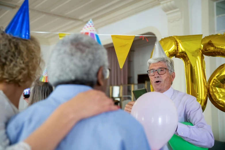 a group of people standing next to each other at a party, by Julian Hatton, pexels contest winner, an oldman, man holding a balloon, dementia, promo image
