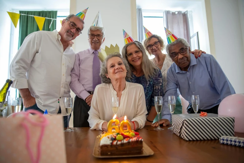 a group of people standing around a table with a birthday cake, a portrait, by Pamela Drew, pexels, elderly, portrait image, thumbnail, close - up portrait shot