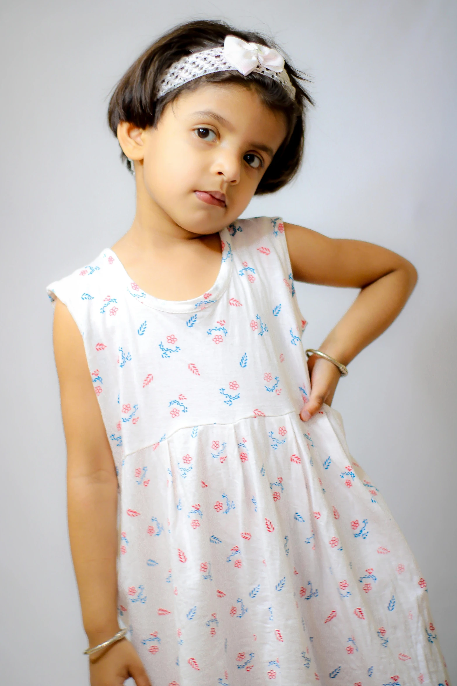 a little girl in a white dress posing for a picture, blue and pink shift, shot with sony alpha, white long tanktop, white background!!!!!!!!!!