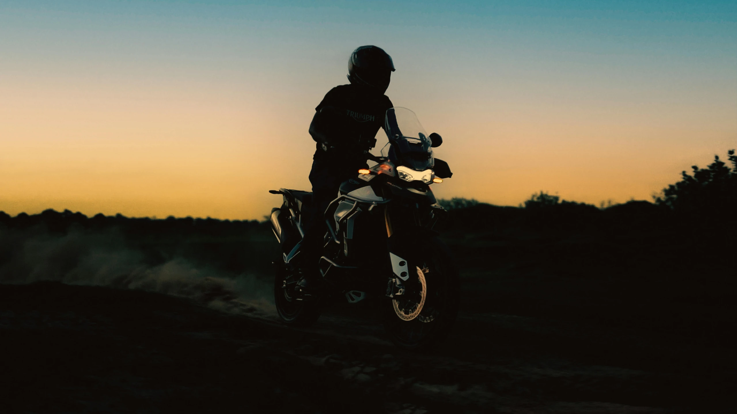 a person riding a motorcycle on a dirt road, pexels contest winner, night time low light, avatar image, triumph, morning sunlight