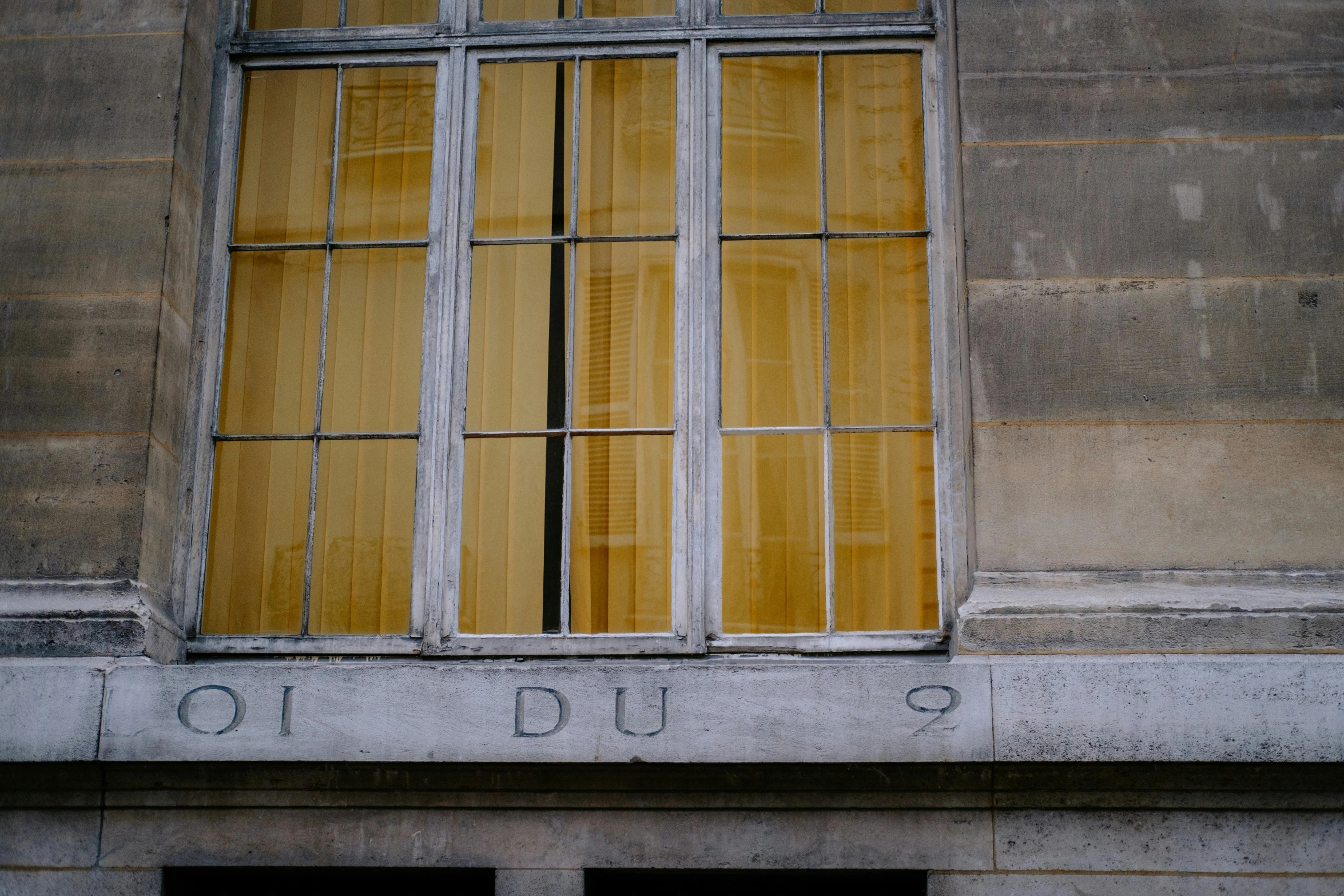 a couple of windows sitting on the side of a building, inspired by Jacques Daret, paris school, vibrant but dreary gold, subtitles, dio, close - up photograph