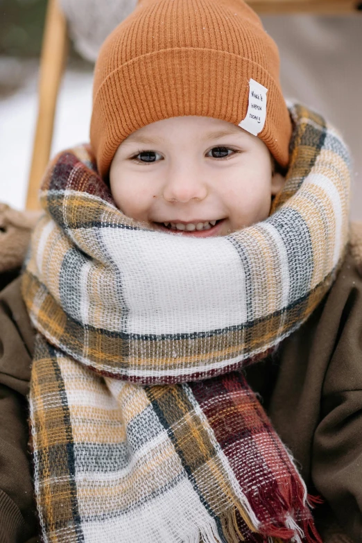 a close up of a child wearing a hat and scarf, premium quality, trending photo, thumbnail, ready to eat