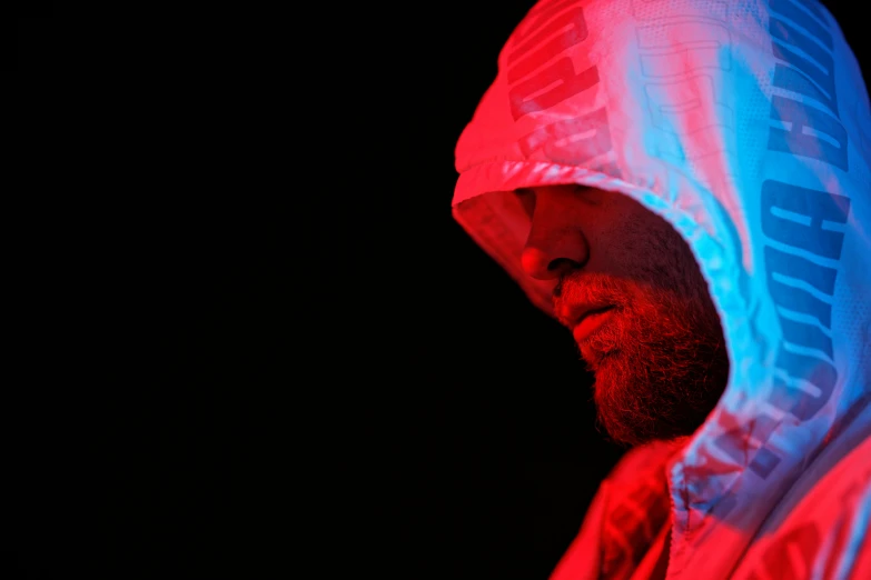a close up of a person wearing a hoodie, by Adam Marczyński, volumetric lighting. red, luminescent fabrics, limp bizkit performing in heaven, high key lighting