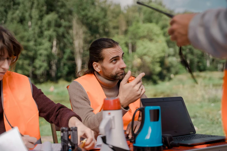 a group of people sitting around a table with a laptop, nature photo, worksafe. cinematic, daniil kudriavtsev, maintenance