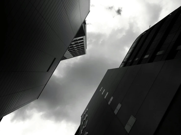 a couple of tall buildings sitting next to each other, a black and white photo, unsplash, minimalism, morphosis, in neotokyo, . dramatic angle, dark-esque