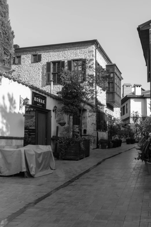 a black and white photo of a narrow street, a black and white photo, by Tamas Galambos, 2 5 6 x 2 5 6, restaurant in background, turkey, leica 8k still from an a24 film