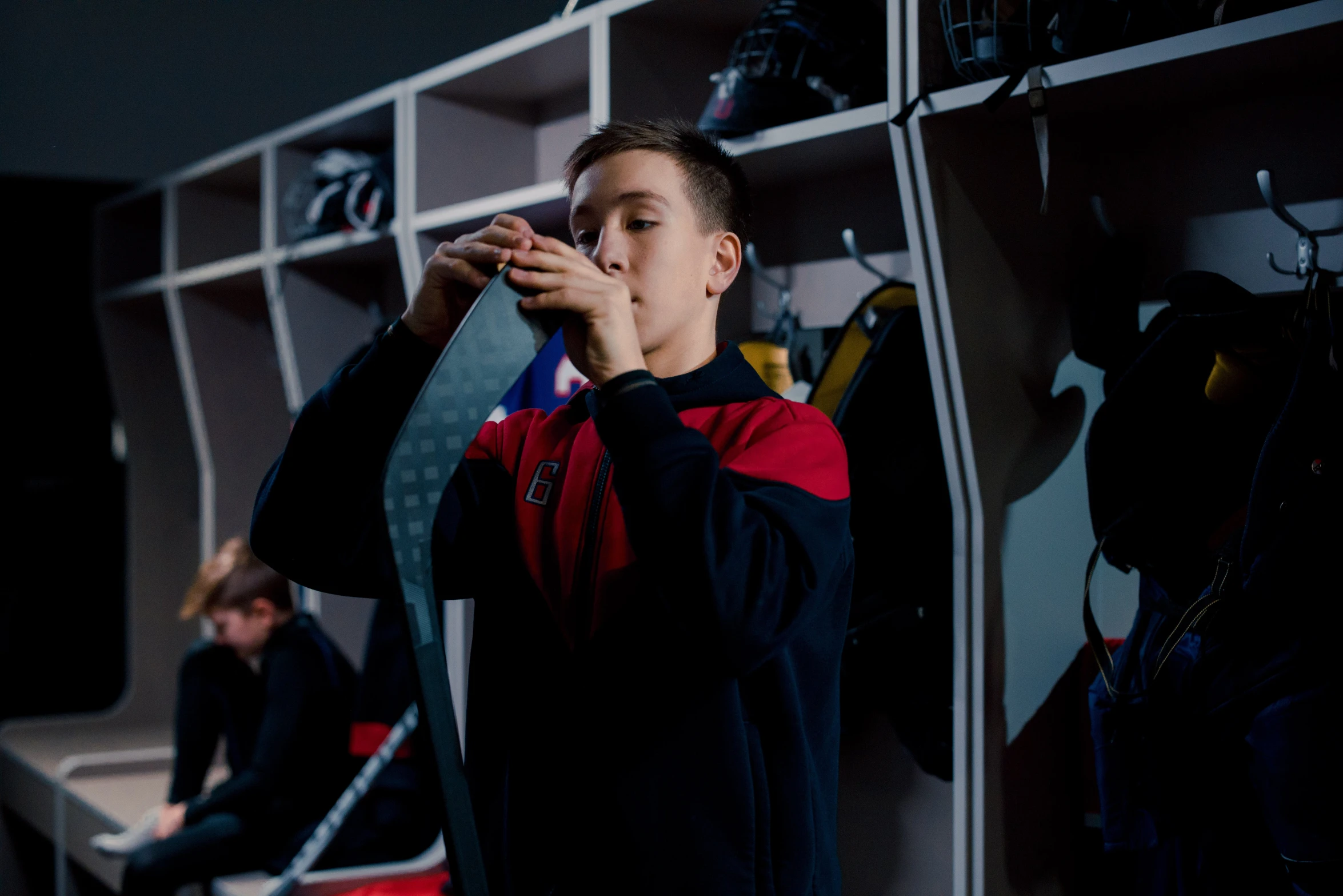 a young man drinking from a bottle in a locker, pexels contest winner, danube school, full ice hockey goalie gear, holding a red lightsaber, behind the scenes photo, boys