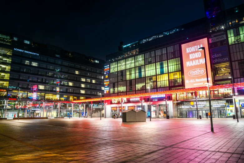 a city street filled with lots of tall buildings, by Jens Søndergaard, unsplash, abandoned mall at night, stockholm, digital billboard in the middle, in a square