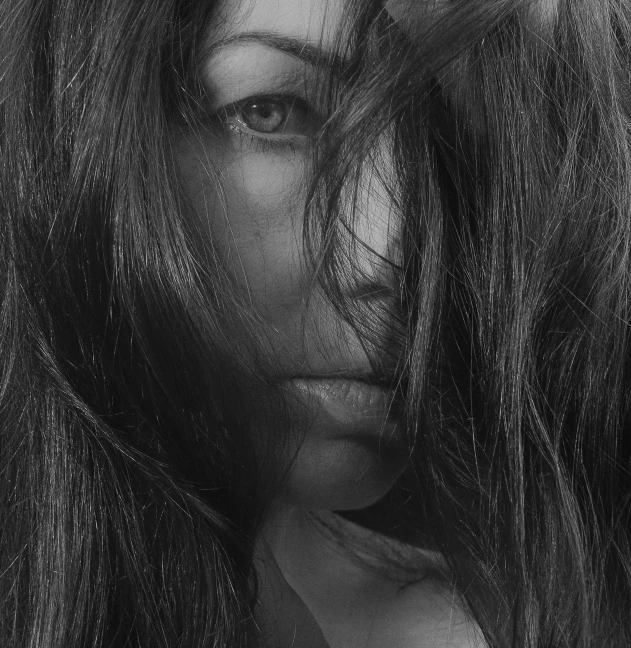 a black and white photo of a woman with long hair, a black and white photo, pexels, hurufiyya, lush unkempt black hair, hair over face, close up portrait of woman, sensual woman