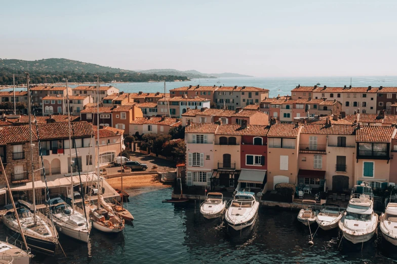 a harbor filled with lots of boats under a blue sky, by Raphaël Collin, pexels contest winner, les nabis, french village exterior, moody : : wes anderson, flatlay, 🦩🪐🐞👩🏻🦳