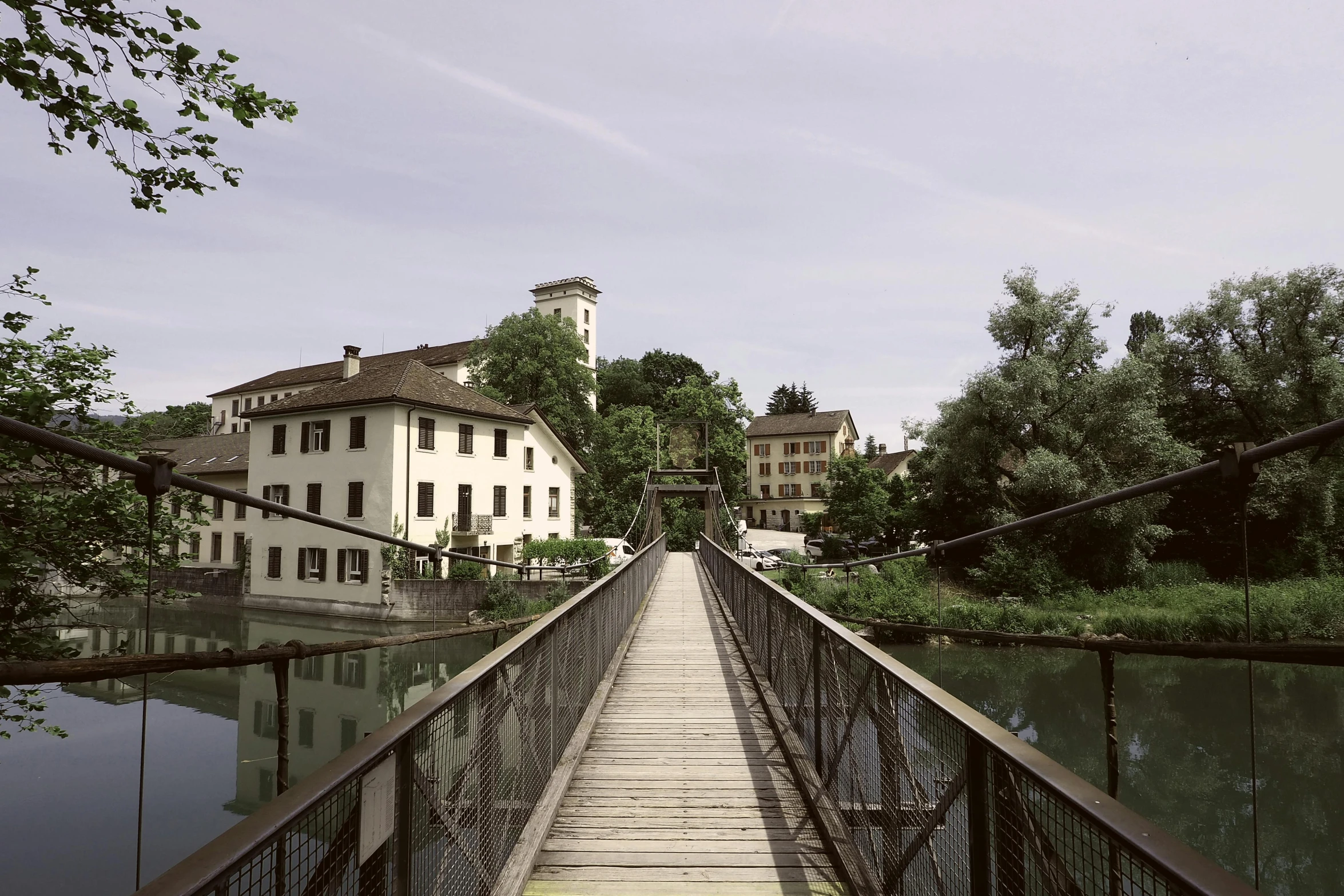 a bridge over a body of water with a building in the background, inspired by Otto Meyer-Amden, unsplash, renaissance, small town surrounding, 2 0 0 0's photo, gopro photo, sparsely populated