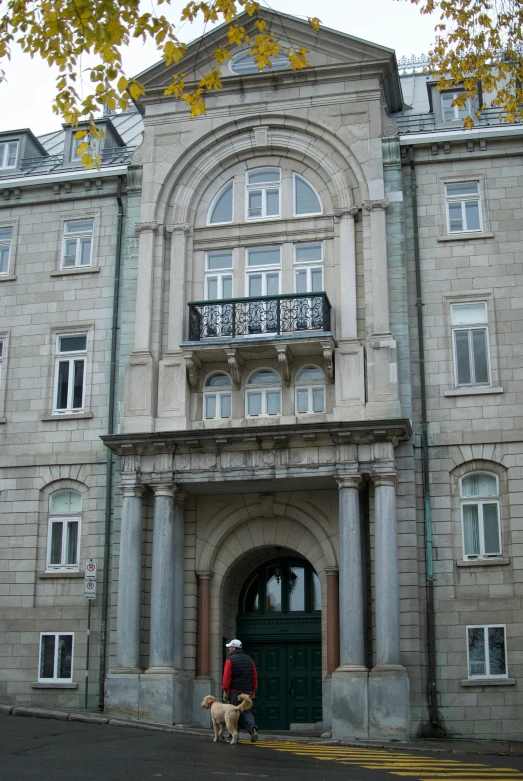 a person walking a dog in front of a building, inspired by Maties Palau Ferré, art nouveau, reykjavik junior college, balcony door, on a great neoclassical square, opposite the lift-shaft
