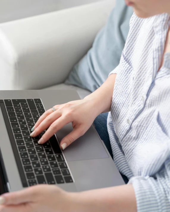 a woman sitting on a couch using a laptop computer, pexels, transgender, worksafe. instagram photo, background image, uncropped