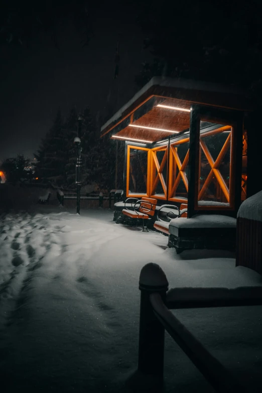 a cabin lit up at night in the snow, a picture, by Sebastian Spreng, pexels contest winner, graffiti, dark city bus stop, bench, thumbnail, high quality image