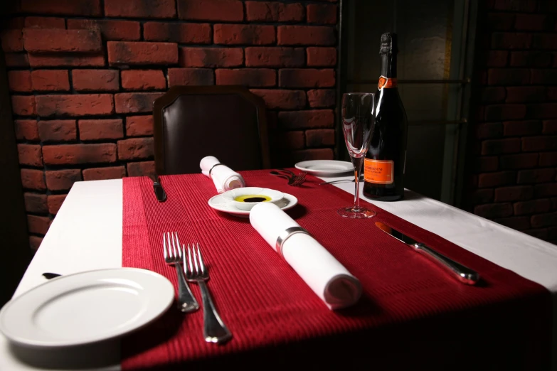 a white plate sitting on top of a table next to a bottle of wine, by Adam Marczyński, red cloth, dining table, item, restaurant