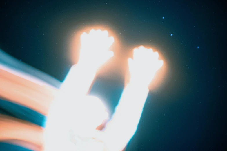 a blurry photo of a person with their hands in the air, an album cover, inspired by Beeple, light and space, gemini star formation, webgl render, ☁🌪🌙👩🏾, flares anamorphic