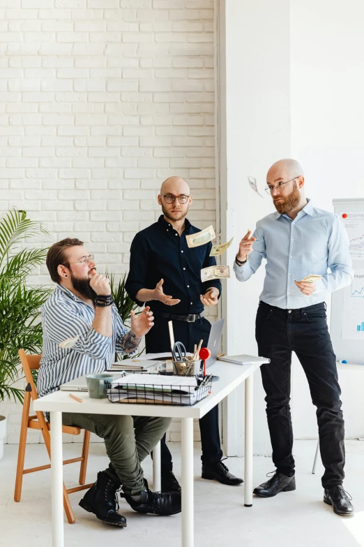 a group of men standing around a table, by Adam Marczyński, pexels contest winner, clean design, bald, product introduction photo