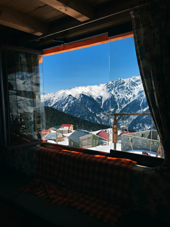 a window with a view of a snowy mountain range, by Muggur, pexels contest winner, hurufiyya, full room view, square, hotel room, 1999 photograph