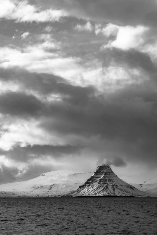 a black and white photo of a snow covered mountain, by Þórarinn B. Þorláksson, process art, ziggurat, stormy setting, in muted colours, 4 0 0 mm