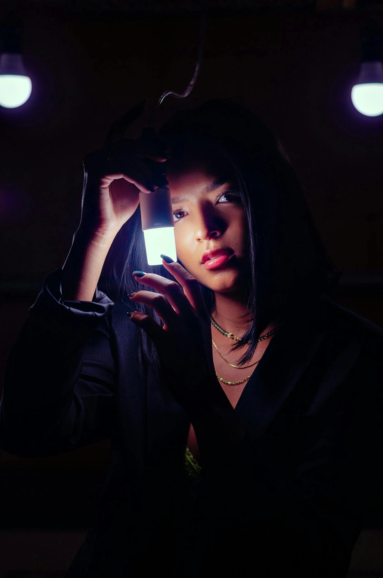 a woman holding a cell phone up to her ear, an album cover, trending on pexels, dim flashlight lighting, bella poarch, looking to camera, jewelry lighting