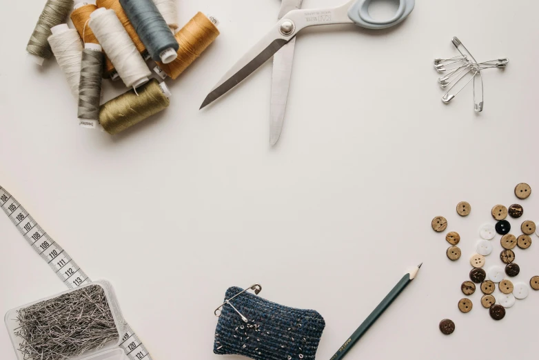 sewing supplies laid out on a white surface, a cross stitch, trending on pexels, 🦩🪐🐞👩🏻🦳, robb cobb, silver accessories, construction