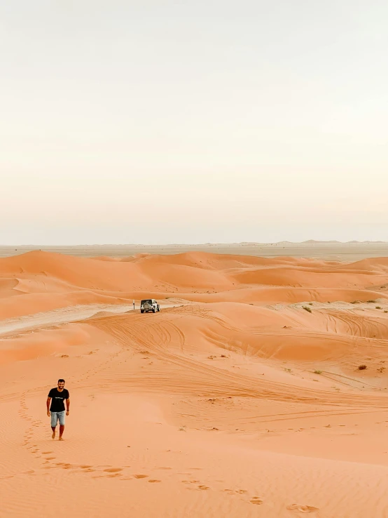 a man standing in the middle of a desert, 🚿🗝📝, red caviar instead of sand, walking over sand dunes, in a vast serene landscape