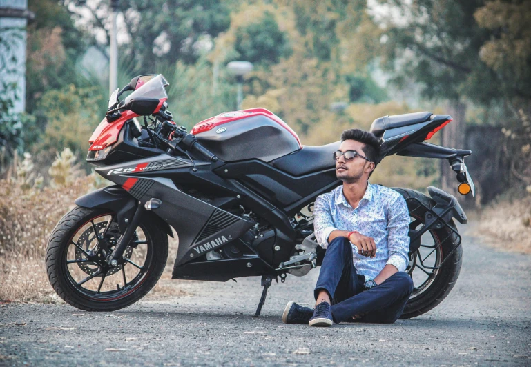 a man sitting on the ground next to a motorcycle, pexels contest winner, jayison devadas, with a sleek spoiler, avatar image, sporty