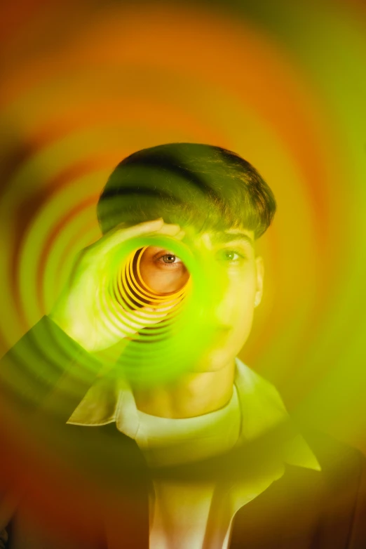 a man with a green light on his face, an album cover, by Doug Ohlson, trending on pexels, holography, spirals in eyes, futuristic yellow lens, shinji, optic ripple