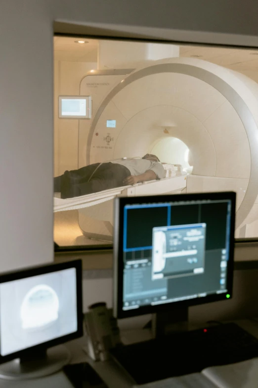 a man sitting at a desk in front of a computer, holography, mri, humans sleeping in healing pods, utrecht, brown