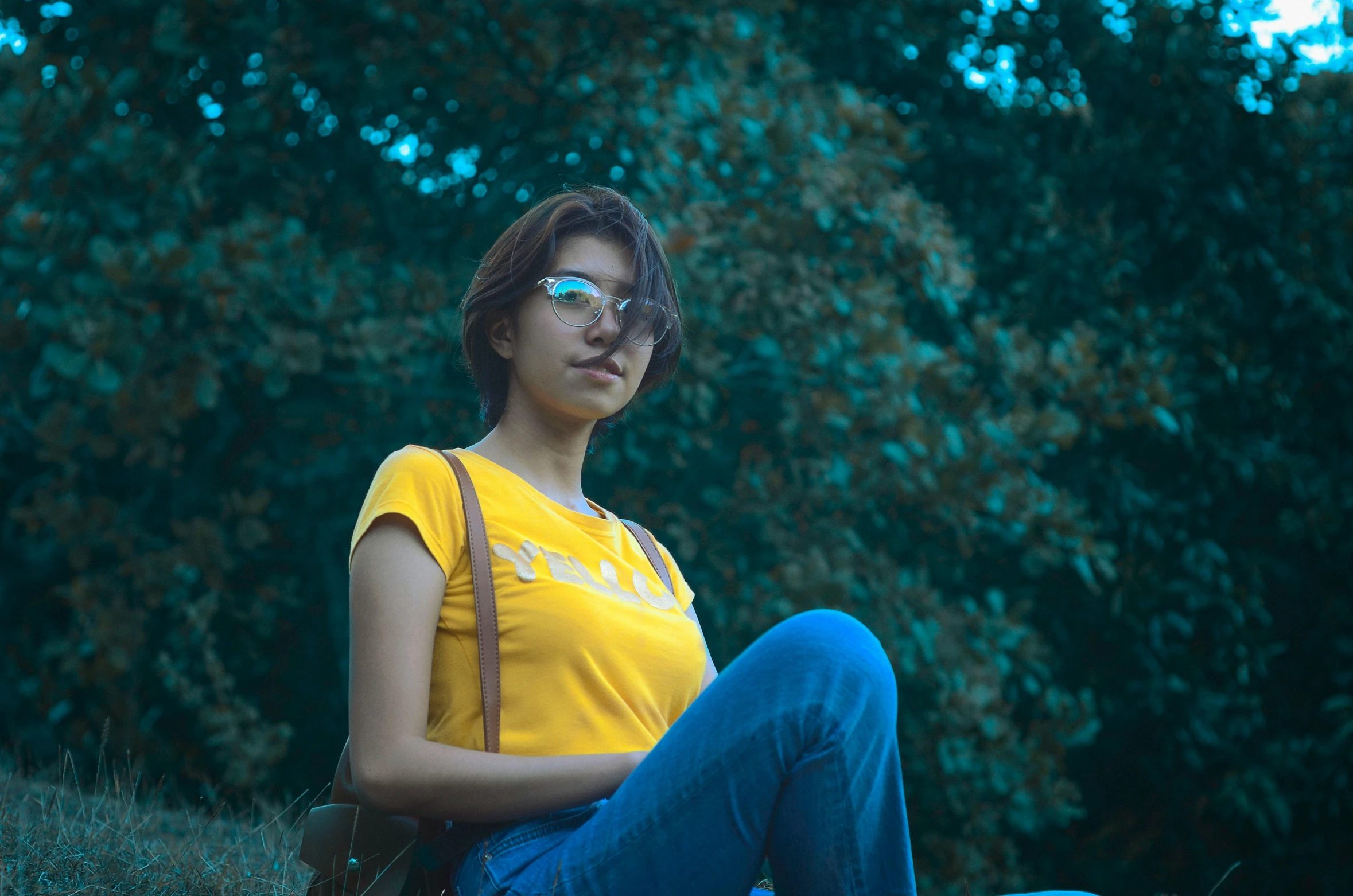 a woman sitting on top of a lush green hillside, inspired by Elsa Bleda, pexels contest winner, realism, wearing a modern yellow tshirt, mia khalifa, 🤤 girl portrait, sitting on a park bench