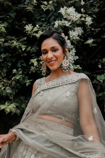 a woman in a wedding dress posing for a picture, wearing a sari, silver and muted colors, photoshoot for skincare brand, candid photo