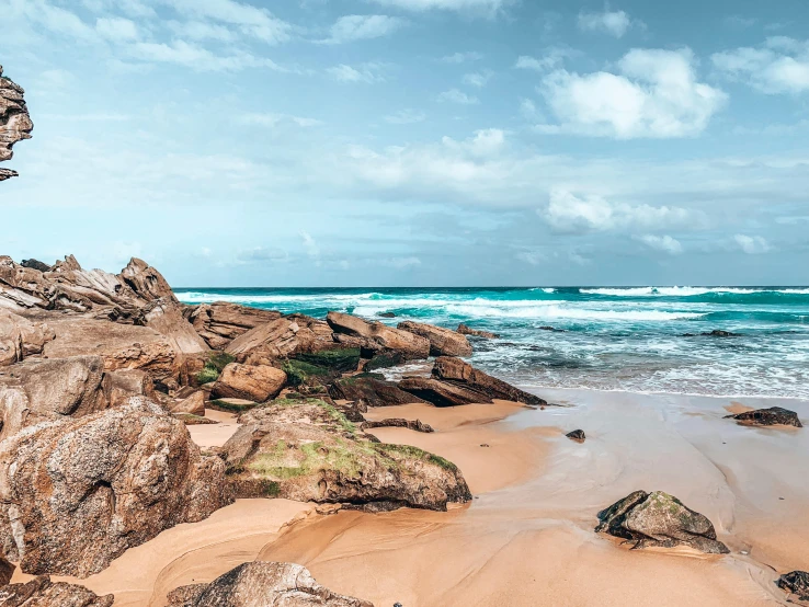 a beach with rocks and a body of water, pexels contest winner, gold coast australia, cornwall, slightly pixelated, brown