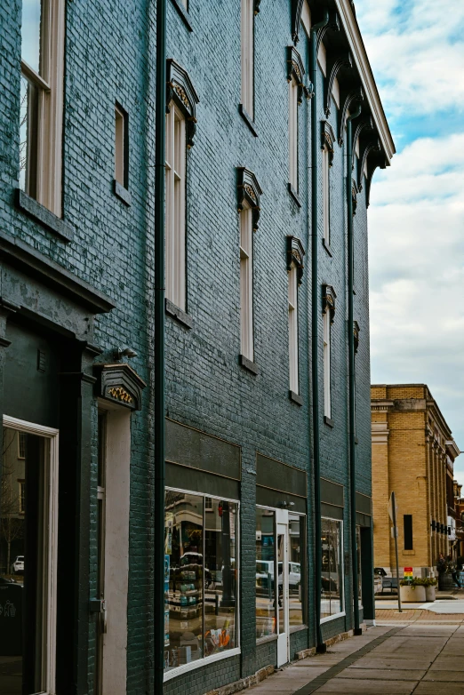 a red fire hydrant sitting on the side of a street, by Lee Loughridge, pexels contest winner, renaissance, tall windows, picton blue, buildings covered in black tar, walton's five and dime