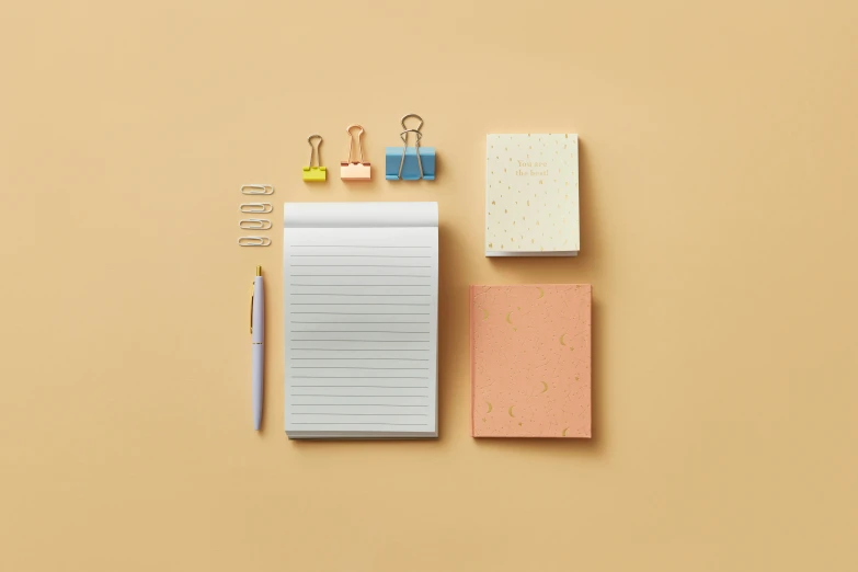 a notepad, pencil, and paper clips on a yellow background, inspired by jeonseok lee, gold speckles, collection product, pink, overview