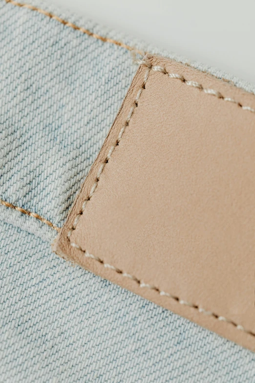 a close up of a pair of jeans with a leather label, by Carey Morris, muted pastels, product view, detaild, light tan