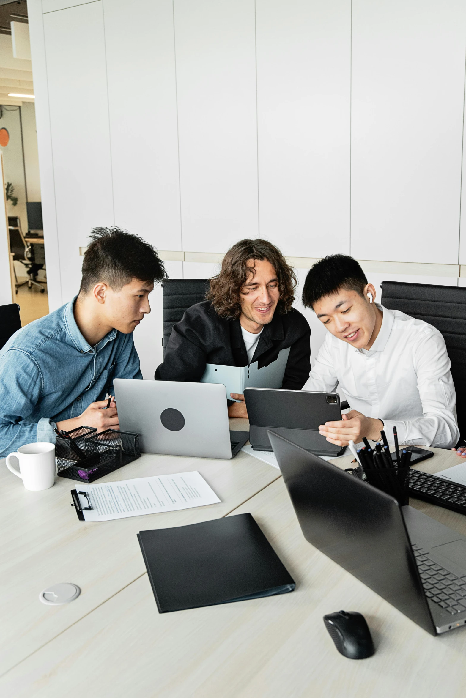 a group of people sitting around a table with laptops, inspired by Fei Danxu, pexels contest winner, engineer, plain background, asian male, working in an office