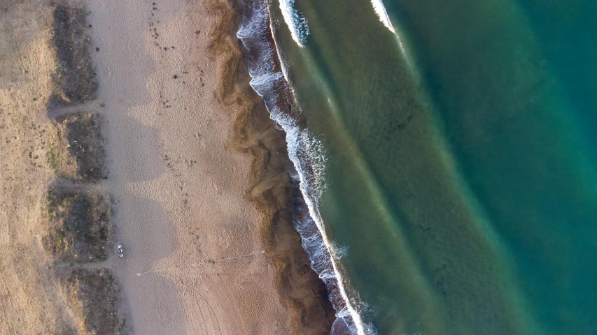 a large body of water next to a sandy beach, by Peter Churcher, pexels contest winner, close-up from above, light and dark, oceanside, 4k —height 1024 —width 1024