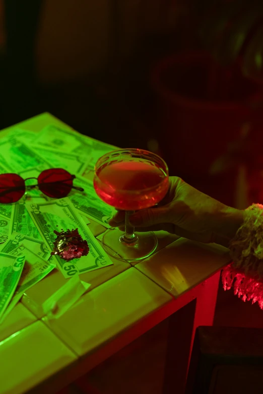 a person sitting at a table with a glass of wine, a hologram, pexels contest winner, renaissance, dollar bills floating, style of suspiria and neon demon, shades green and red, cocktail bar