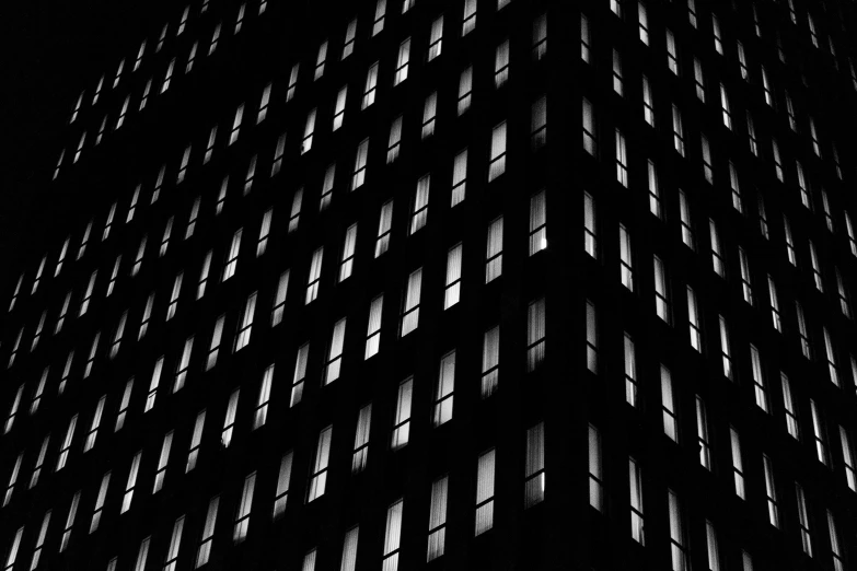a black and white photo of a tall building, by Andrew Domachowski, pexels contest winner, minimalism, windows lit up, detailed abstract, glowing windows, desktop wallpaper