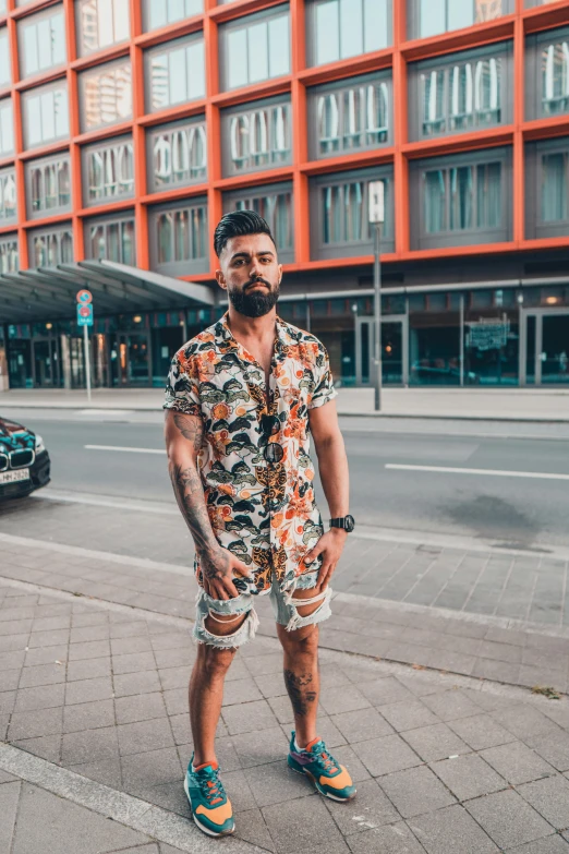 a man standing on a sidewalk in front of a building, by Niko Henrichon, body covered in floral tattoos, instagram influencer, short beard, vacation