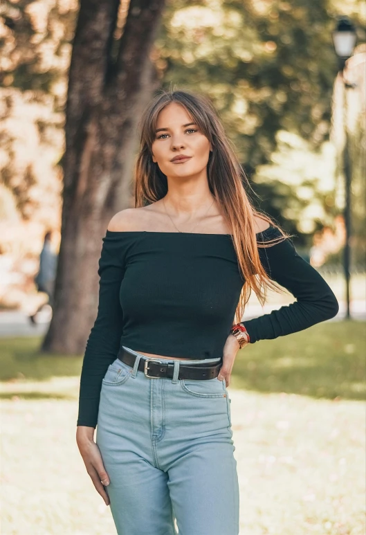 a woman standing in the grass with her hands on her hips, pexels contest winner, off the shoulder shirt, casual black clothing, anna nikonova, wearing a cropped tops