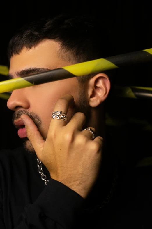 a man holding a pair of scissors over his head, an album cover, inspired by L. A. Ring, trending on pexels, rapper bling jewelry, unibrow, profile image, wearing two metallic rings