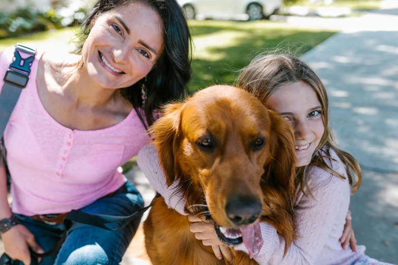 a woman sitting next to a little girl and a dog, manuka, avatar image, golden retriever, close up photograph