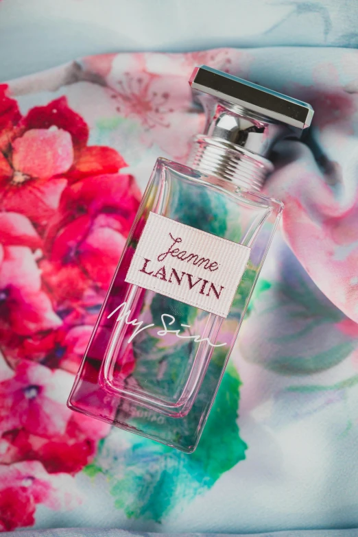 a bottle of lanvin perfume sitting on top of a bed, inspired by Ju Lian, portrait anya taylor-joy, summer sun, in white lettering, flowers