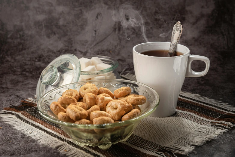 a glass bowl filled with donuts next to a cup of coffee, inspired by Ödön Márffy, dau-al-set, a hookah smoking caterpillar, background image, grey, traditional medium